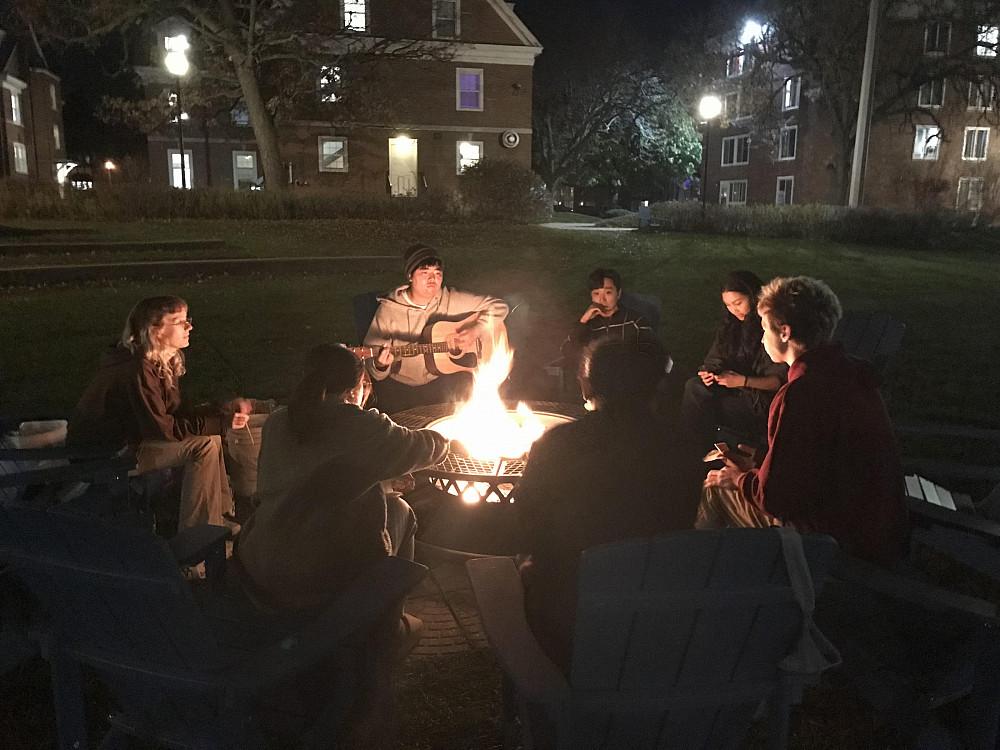 Students enjoy each others' company at a bonfire at Aldrich field.
